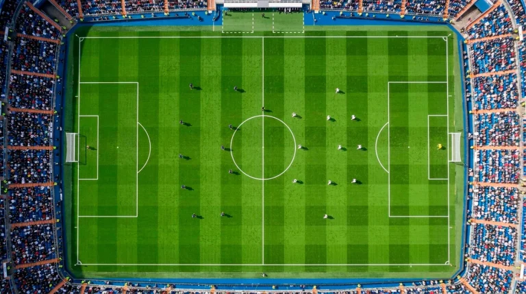 Vista cenital de un campo de fútbol de la Premier League con líneas marcadas sobre el césped